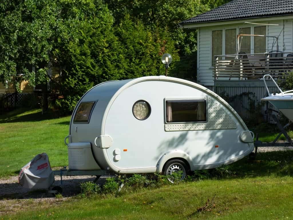 A small teardrop caravan parked on a lawn